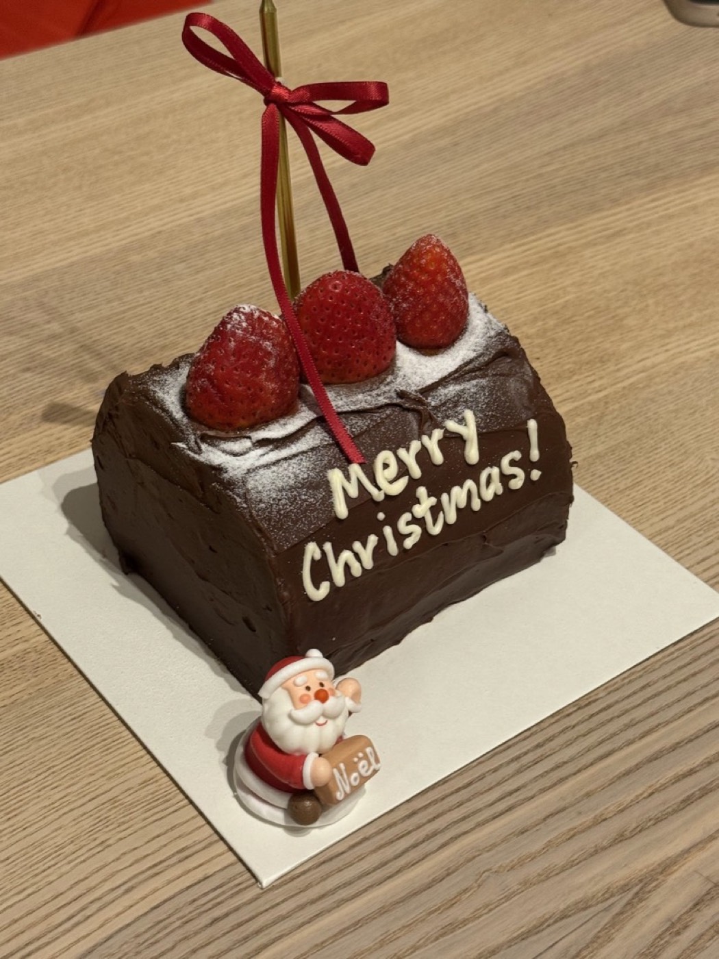 Chocolate cake finished as a Christmas yule log with strawberries and a Merry Christmas message