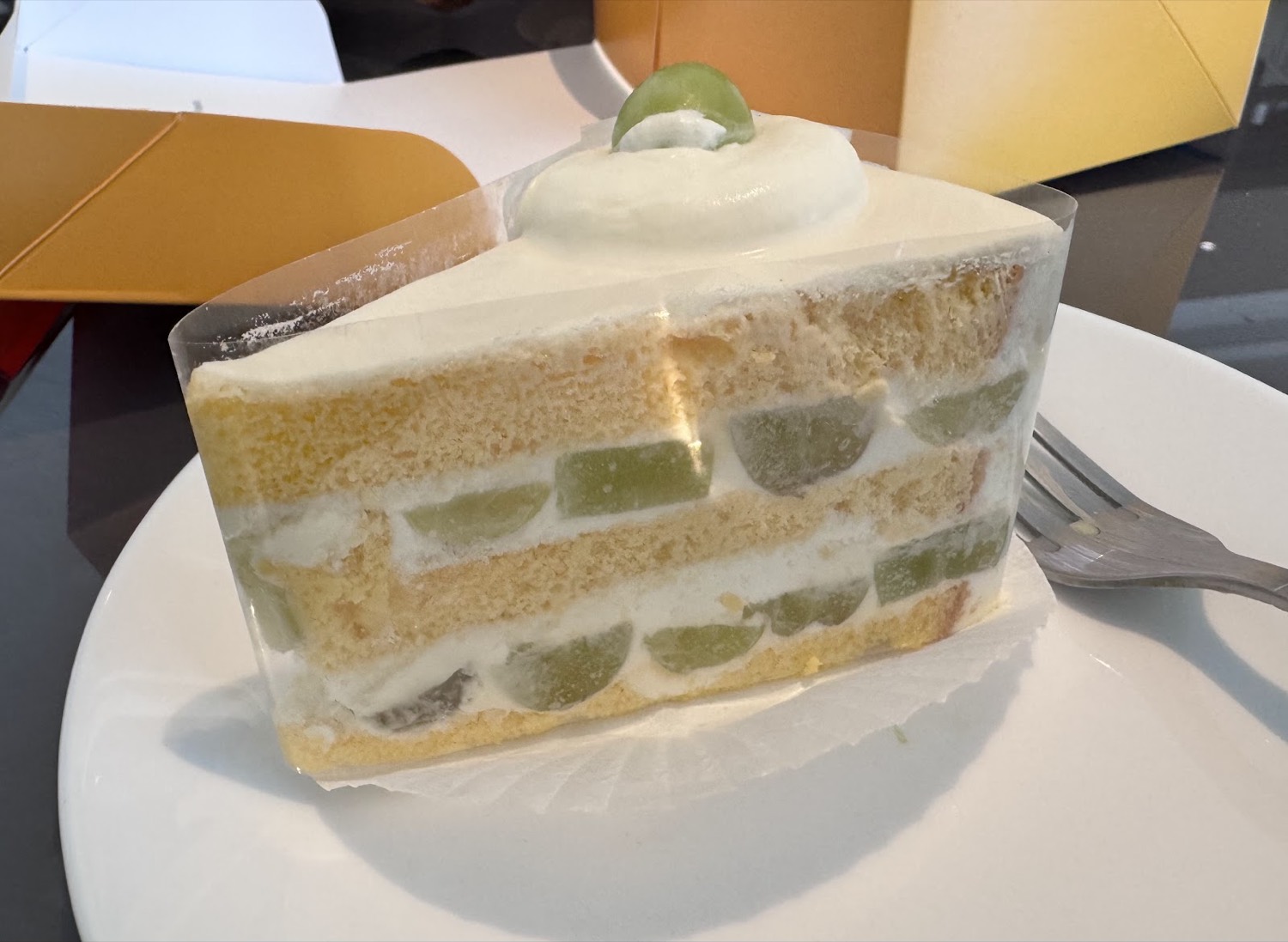 A slice of Mille's grape-and-cream sponge cake, layered with cream and fresh green grapes and topped with a grape