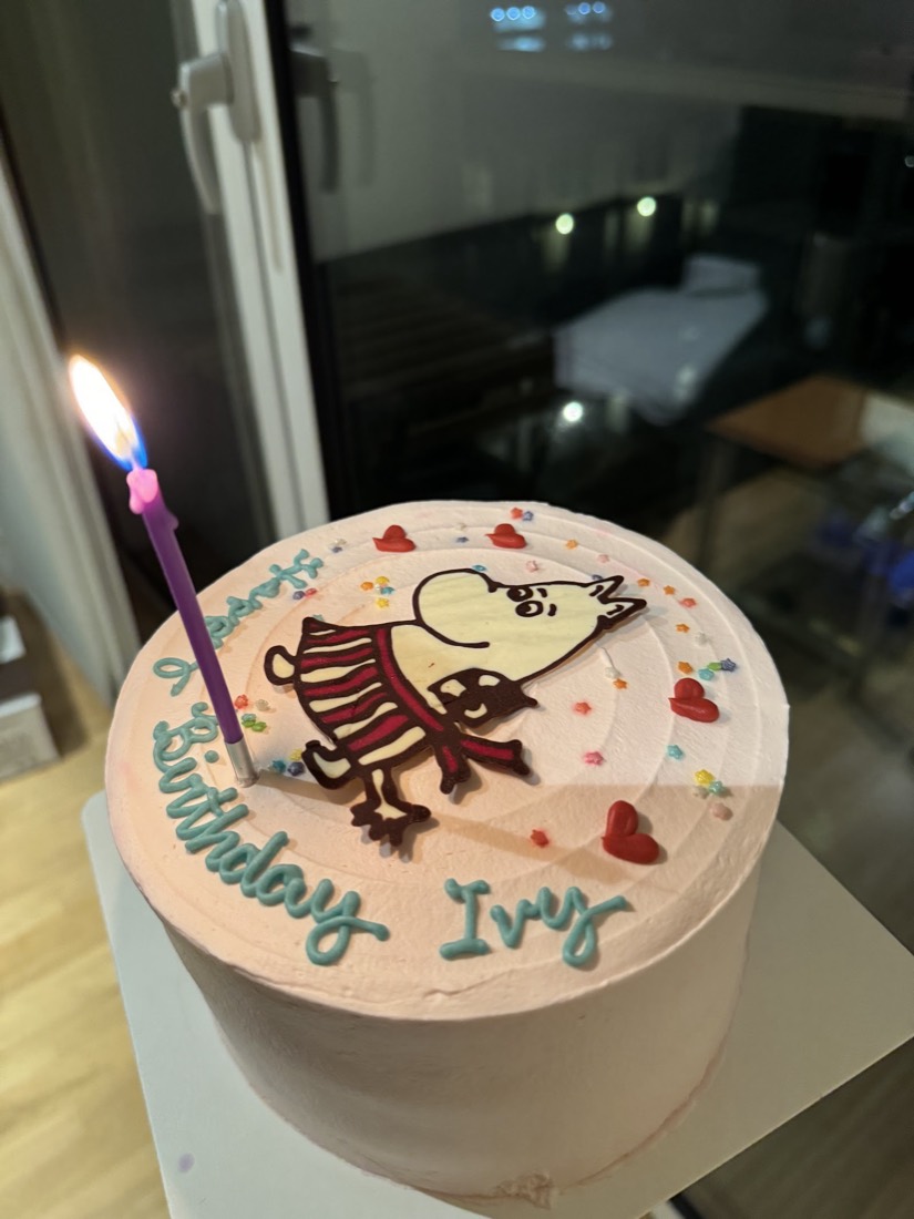 Pink birthday cake with a hand-piped character and Happy Birthday message