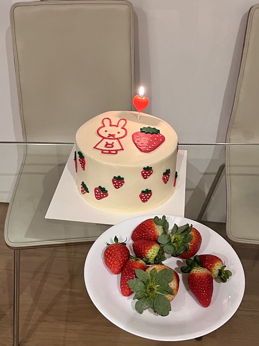 Cream cake hand-piped with a bunny and strawberries, fresh strawberries alongside